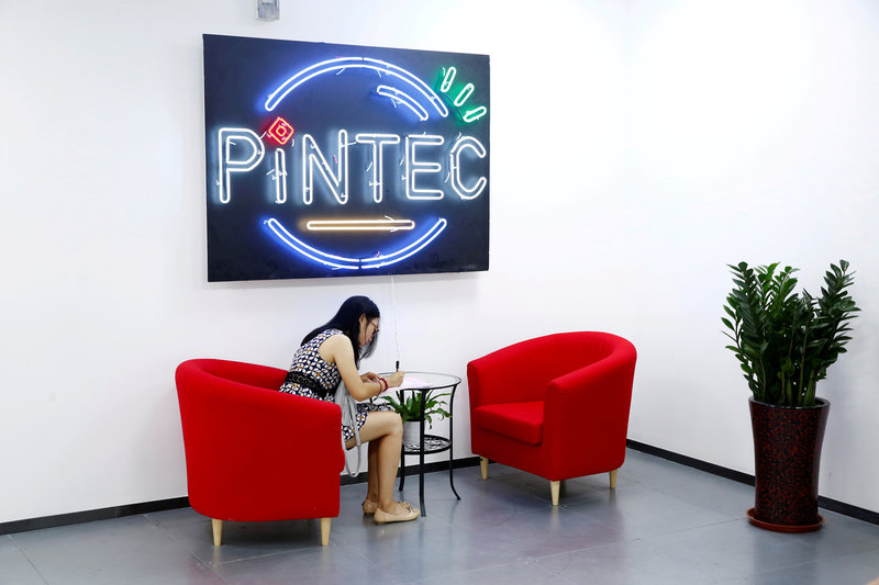 FILE PHOTO: A woman sits in the reception area of PINTEC Group in Beijing