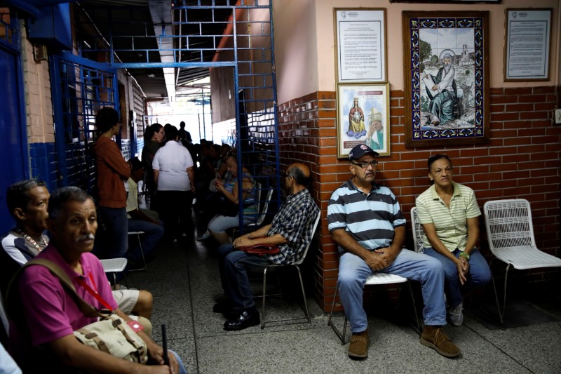 Venezuelan citizens wait to cast their votes in a polling station during a nationwide election for new governors in Caracas