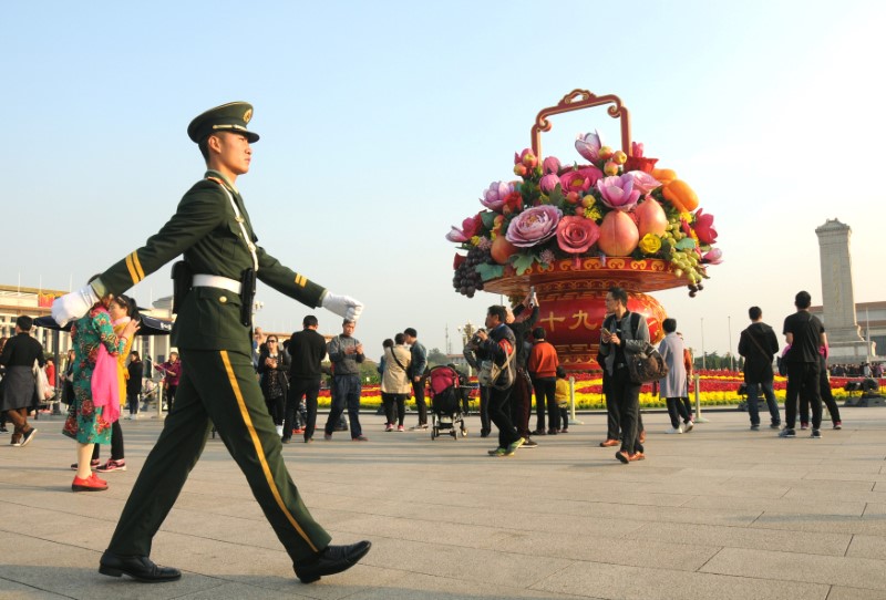 A paramilitary police officer patrols the area around Tiananmen Square in Beijing