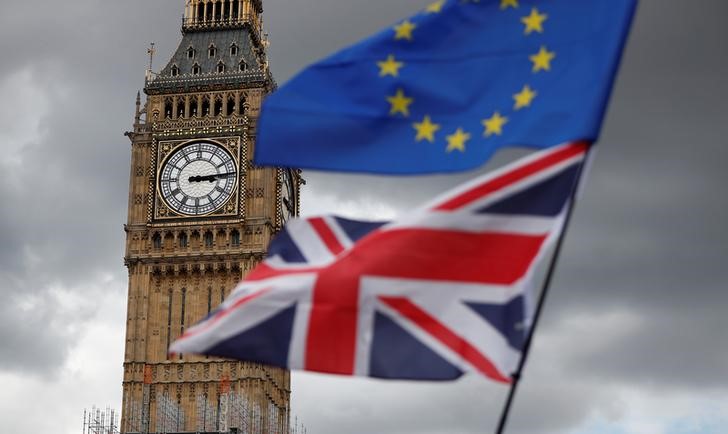 FILE PHOTO - The Union Flag and a European Union flag fly near the Elizabeth Tower, housing the Big Ben bell, during the anti-Brexit 'People's March for Europe', in Parliament Square in central London
