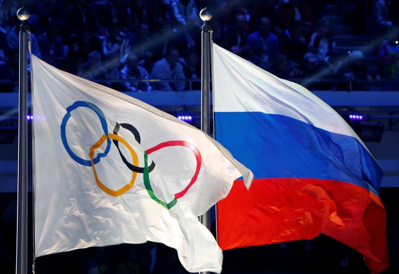 FILE PHOTO: The Russian national flag and the Olympic flag are seen during the closing ceremony for the 2014 Sochi Winter Olympics