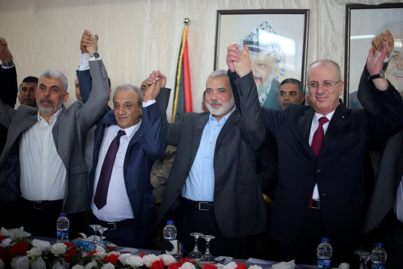 FILE PHOTO: Palestinian Prime Minister Rami Hamdallah and Hamas Chief Ismail Haniyeh hold hands in Gaza City