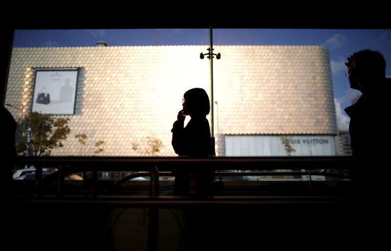 A woman is silhouetted against a department store at Apgujeong luxury shopping district in Seoul