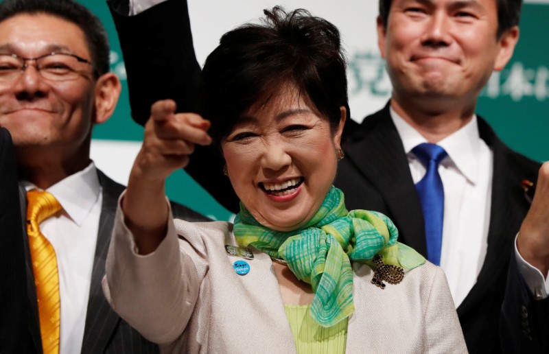 Tokyo Governor Koike, leader of new Party of Hope, smiles as she raises her fist with her party members during a news conference to announce the party's campaign platform in Tokyo