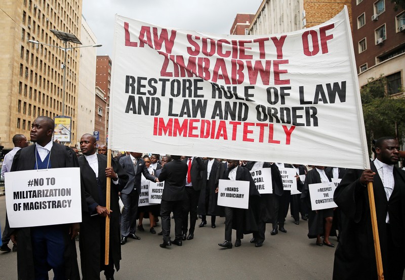 Zimbabwean lawyers carry placards as they march to demand justice for people detained in jail and others facing fast-track trials following recent protests in Harare