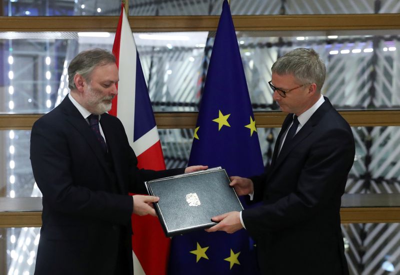 Britain's Ambassador to the European Union Tim Barrow delivers the instruments of ratification for Brexit, to European Council Secretary General Jeppe Tranholm-Mikkelsen in Brussels