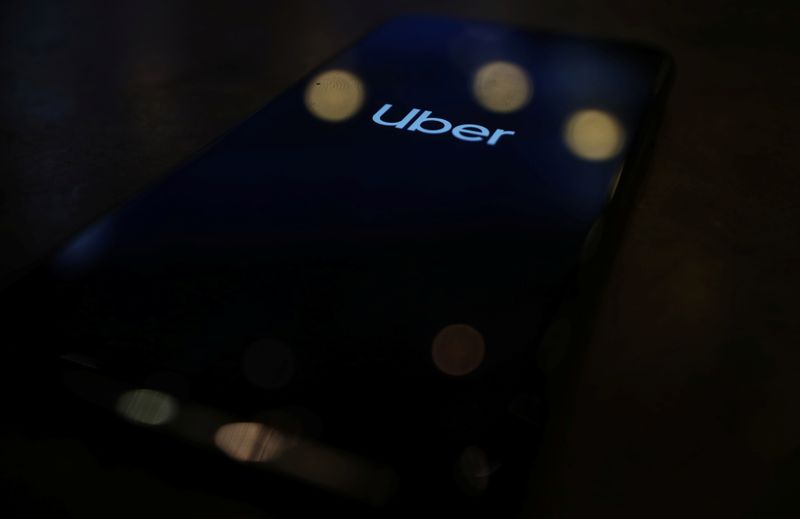 The Uber logo is displayed on a mobile phone in this picture illustration