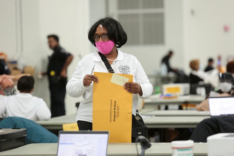 A poll worker supervisor handles an envelope of original ballots at the TCF center after Election Day in Detroit, Michigan