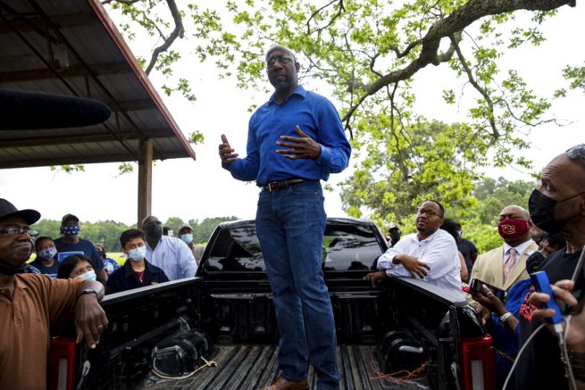 U.S. Sen. Rev. Raphael Warnock speaks with Black farmers in Byromville, Ga., on Tuesday, May 4, 2021. Warnock addressed targeted federal relief in the American Rescue Plan for farmers of color and vowed to tackle the history of discriminatory practices by the United States Department of Agriculture. (Riley Bunch/The Daily Times via AP)