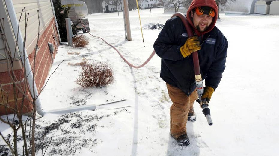 In this Jan. 7, 2014, file photo, Denver Walker, of Somerset Fuels, makes a heating oil delivery to a home in Jenner Crossroads, Pennsylvania.