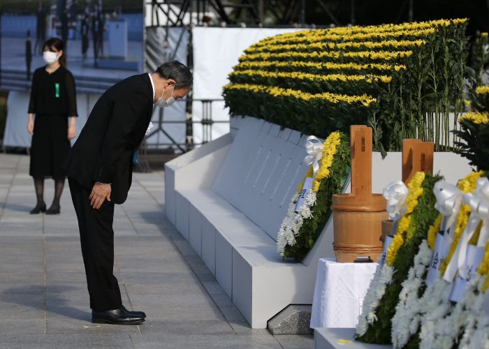 Japan's Prime Minister Yoshihide Suga (L) pays his respects during a ceremony to mark the 76th anniversary of the world's first atomic bomb attack at the Peace Memorial Park in Hiroshima on August 6, 2021. - Japan OUT (Photo by STR / JIJI PRESS / AFP) / Japan OUT (Photo by STR/JIJI PRESS/AFP via Getty Images)