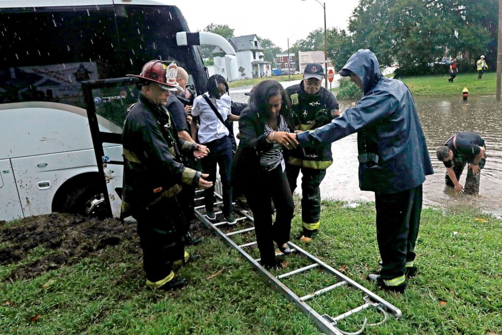 PHOTO: Firefighters with Engine House No. 10 assist a group of adults and students off a bus that got stuck in rising flood waters in St. Louis, Ky., July 28, 2022.