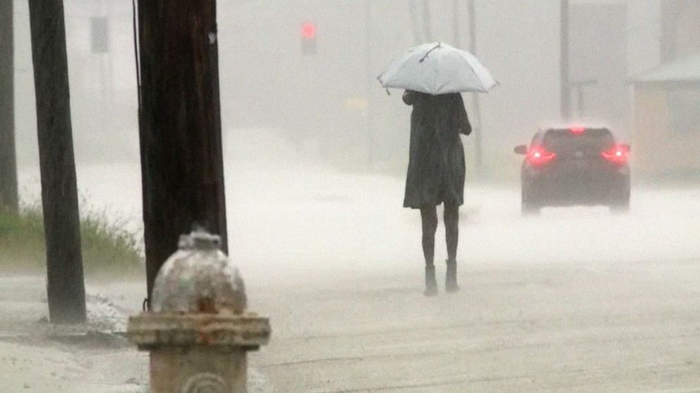 PHOTO: A person walks during the rain deluge in Jackson, Miss., Aug. 23, 2022. 