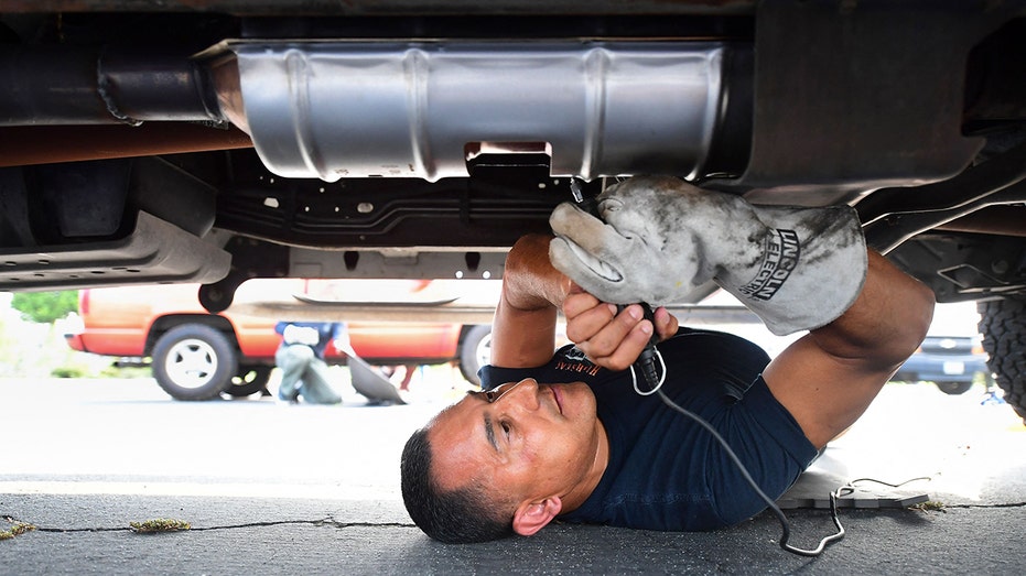Man repairing catalytic converter