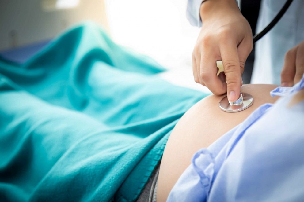 PHOTO: Doctor listening to a pregnant woman's belly with stethoscope.