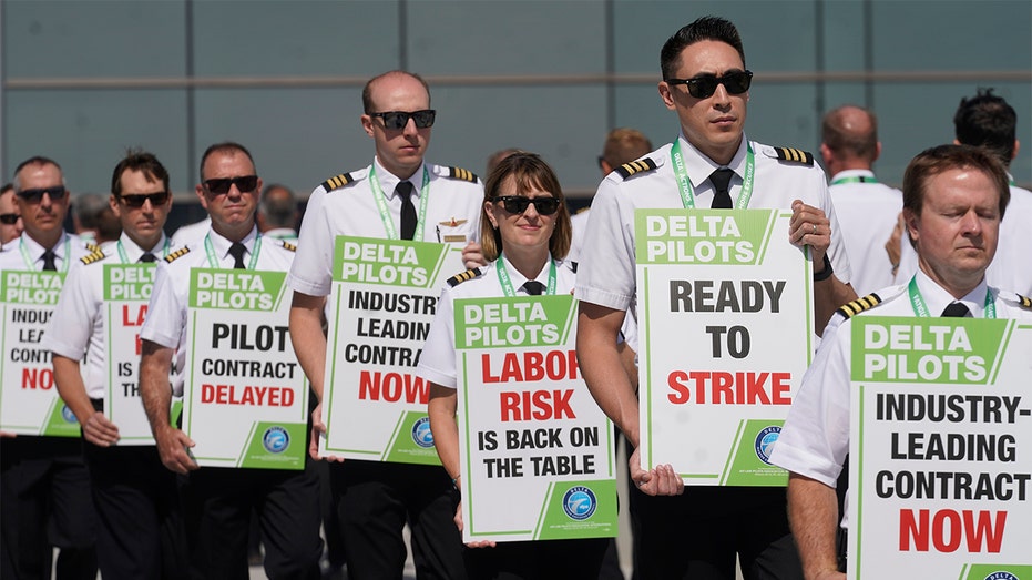 Delta Air Lines pilots march and hold signs at Salt Lake City's airport June 30, 2022.