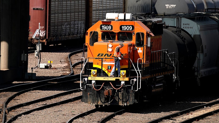 An orange BNSF train at a rail yard