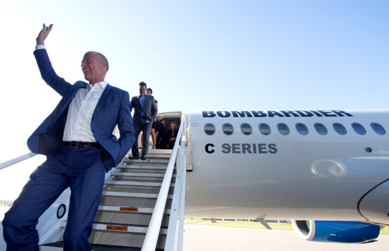 Airbus Chief Executive Tom Enders waves to employees followed by chairman of the board of Bombardier Inc., Pierre Beaudoin after touring a Bombardier CSeries plane at Bombardier's plant in Mirabel