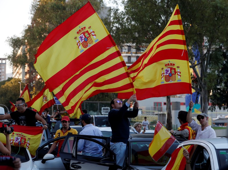 Pro-unity demonstrators wave the Spanish and Catalan flags as they gather in Barcelona