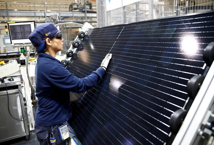 FILE PHOTO: An employee makes a final inspection on panels during a tour of an REC solar panel manufacturing plant in Singapore