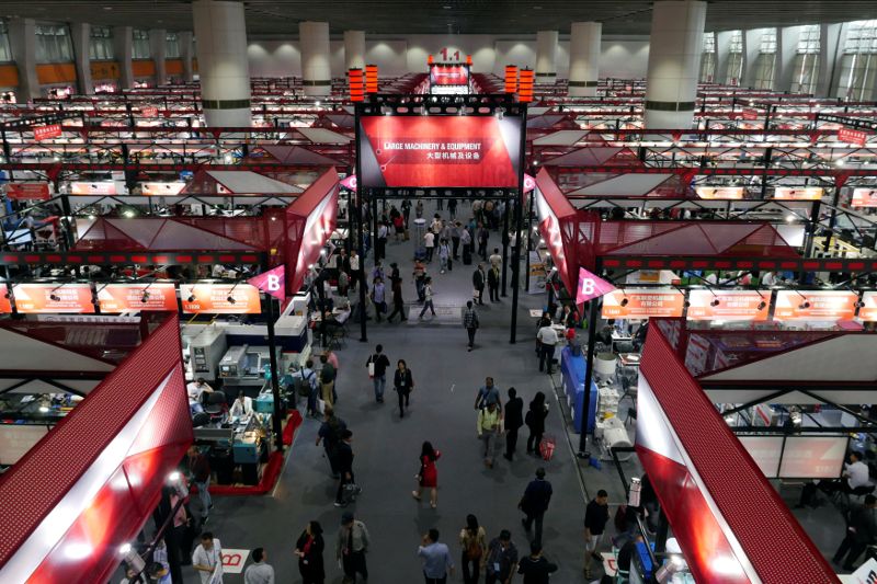 Visitors walk between booths at the Canton Fair in Guangzhou