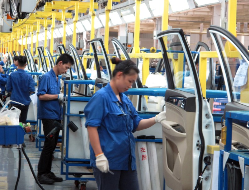Employees work at a production line inside a factory of Saic GM Wuling, in Liuzhou