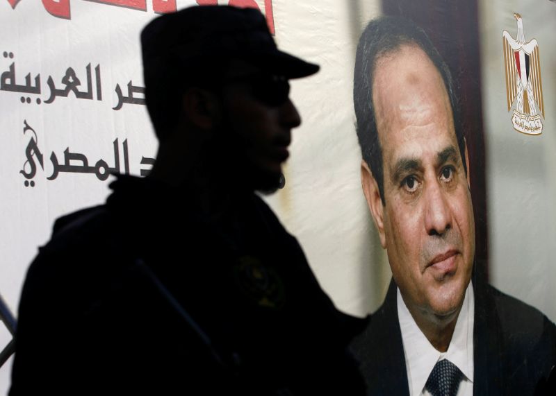 A member of security forces stands guard next to a poster depicting Egypt's President Abdel Fattah al-Sisi as Palestinian Prime Minister Rami Hamdallah arrives to hold a cabinet meeting in Gaza City