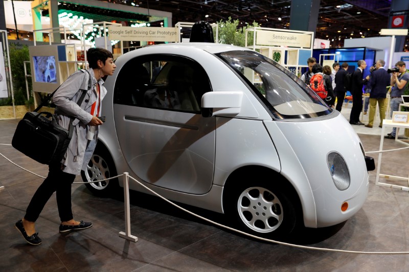 FILE PHOTO: A visitor looks at a self-driving car by Google at the Viva Technology event in Paris