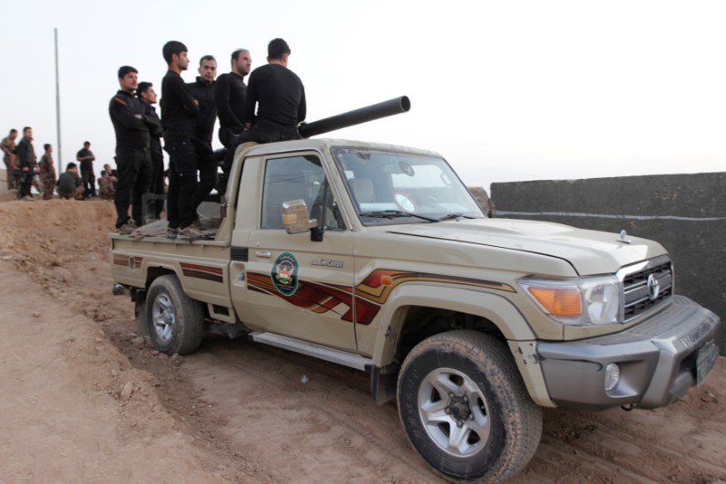 Kurdish Peshmerga fighters ride in a vehicule in the Southwest of Kirkuk