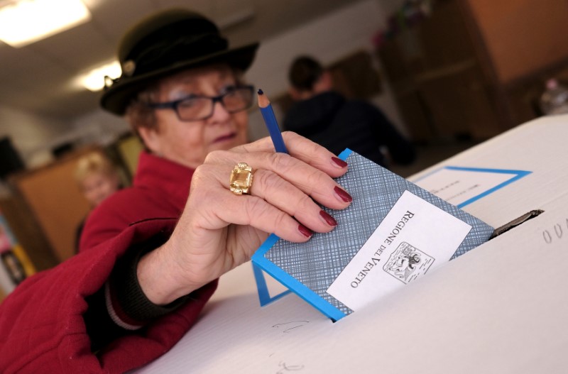 A woman casts her vote for Veneto's autonomy referendum at a polling station in Venice