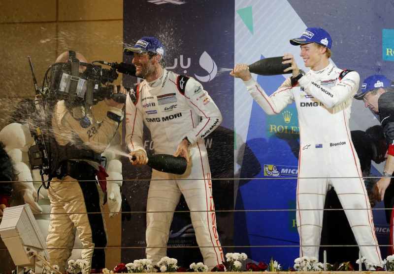 Porsche Team's LP1's drivers Mark Webber of Australia (L) and Brendon Hartley of Australia (R) celebrate after winning the overall first place at the 6-hour World Endurance Championship at Bahrain International Circuit, in Sakhir south of Manama