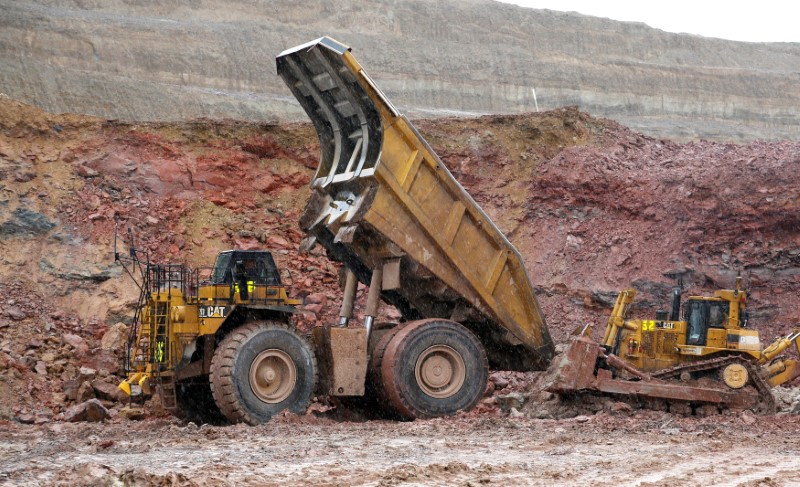 FILE PHOTO: A giant Newmont Mining haul truck which is stuck in the mud gets a push from a conventionally sized bulldozer at Newmont's Carlin gold mine operation near Elko,