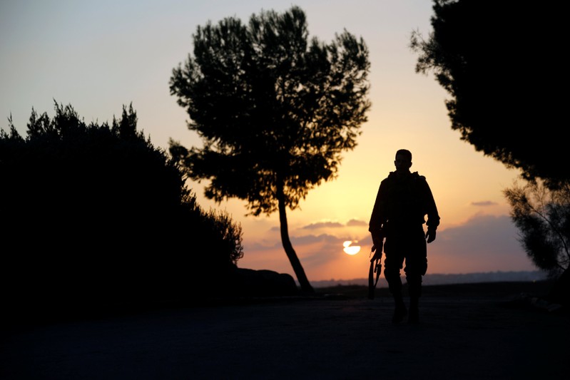 Israeli soldier walks near the border line between Israel and the Gaza Strip, in Israel
