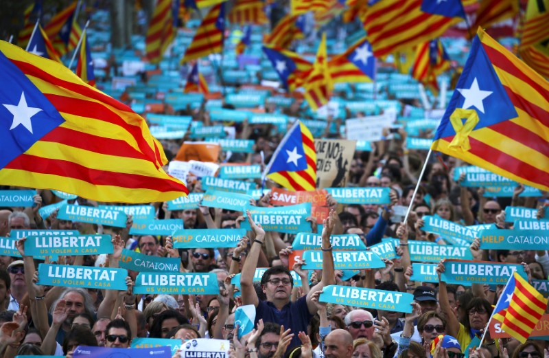 People wave separatisy Catalan flags and placards during a demonstration organised by Catalan pro-independence movements ANC (Catalan National Assembly) and Omnium Cutural, following the imprisonment of their two leaders in Barcelona