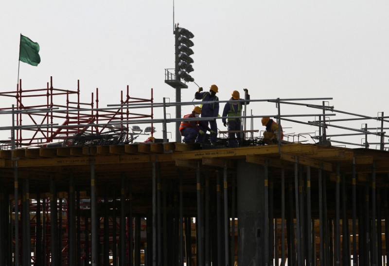 FILE PHOTO: Migrant labourers work at a construction site at the Aspire Zone in Doha