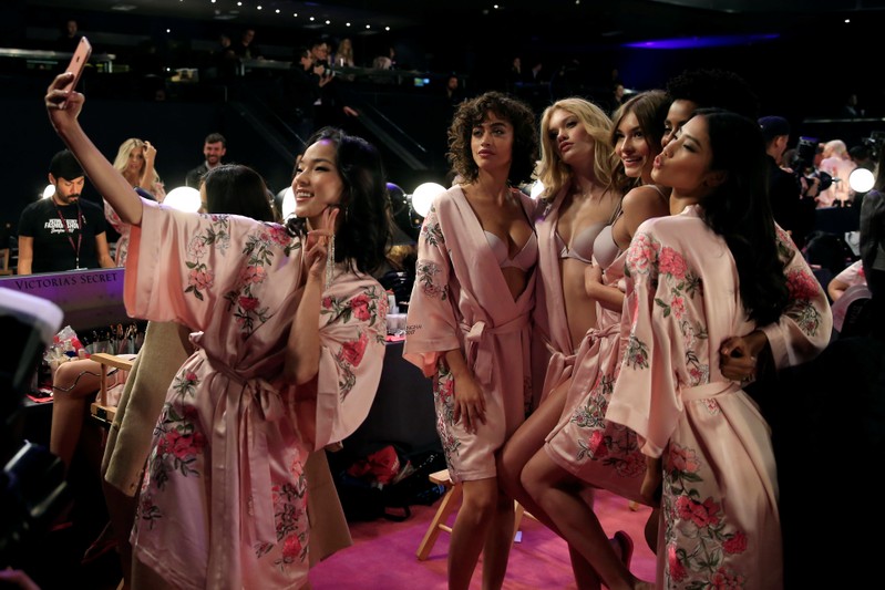 Model Xiao Wen takes pictures with her phone before the 2017 Victoria's Secret Fashion Show in Shanghai