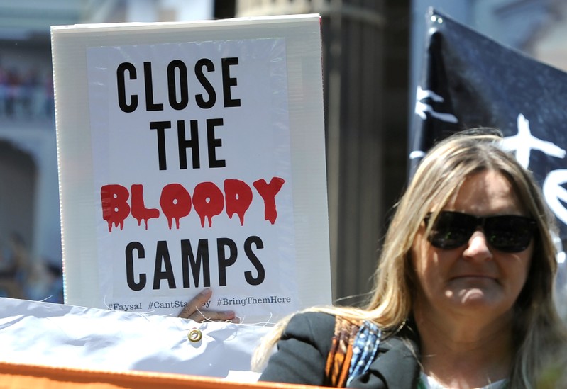 Refugee advocates hold placards and banners during a protest rally in central Melbourne