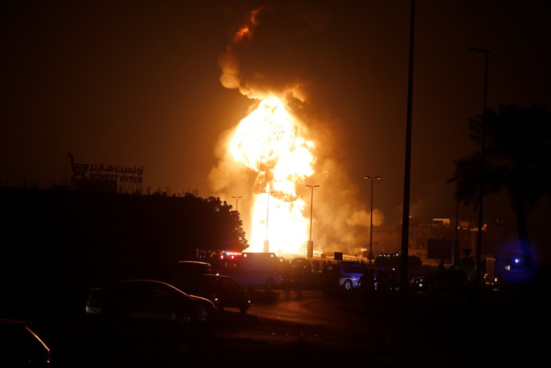 Emergency and rescue workers are seen blocking the road leading to a fire in at oil pipeline in Buri village south of Manama