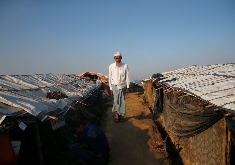A Rohingya refugee man walks along the temporary shelters at Palong Khali refugee camp near Cox's Bazar