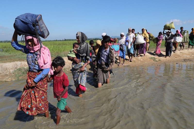Rohingya refugees walk towards a refugee camp after crossing the border in Anjuman Para near Cox's Bazar