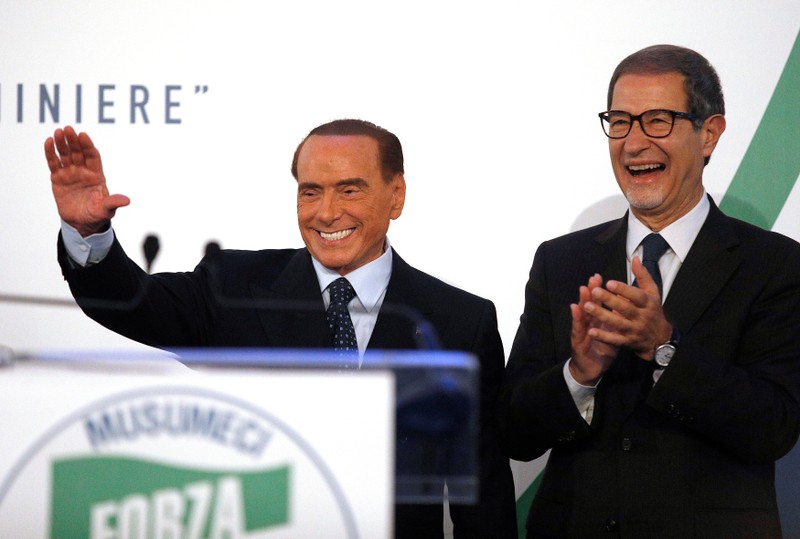 Forza Italia party leader Silvio Berlusconi waves to supporters next to local candidate Nello Musumeci during a rally in Catania