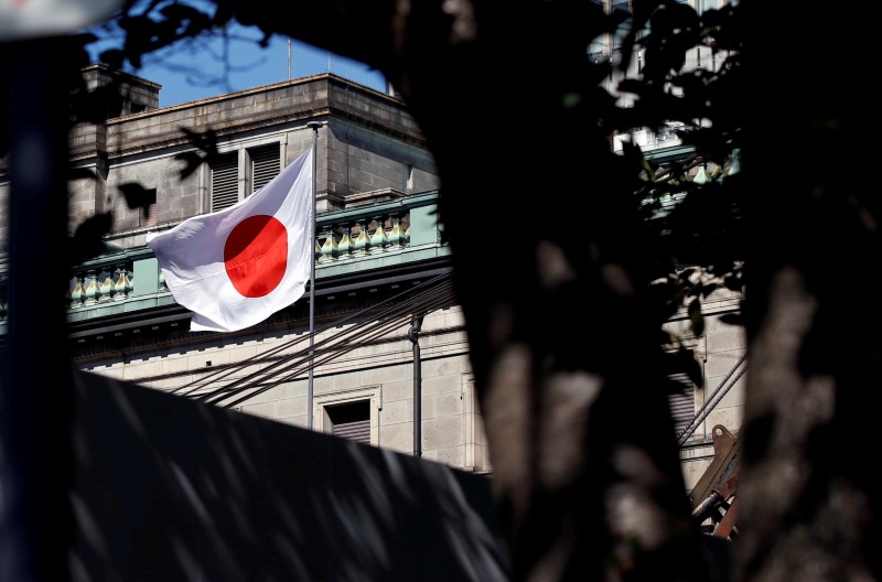 FILE PHOTO: A Japanese flag flutters atop the Bank of Japan building under construction in Tokyo