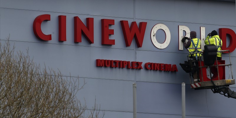 FILE PHOTO - Workers repair a sign at a Cineworld cinema in Bradford northern England.