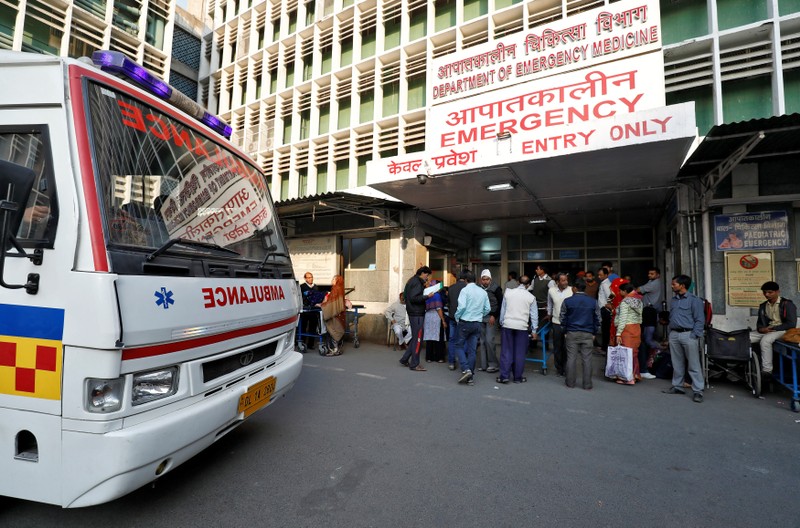 An ambulance arrives as people stand at the entrance of the emergency department of a government-run hospital in New Delhi