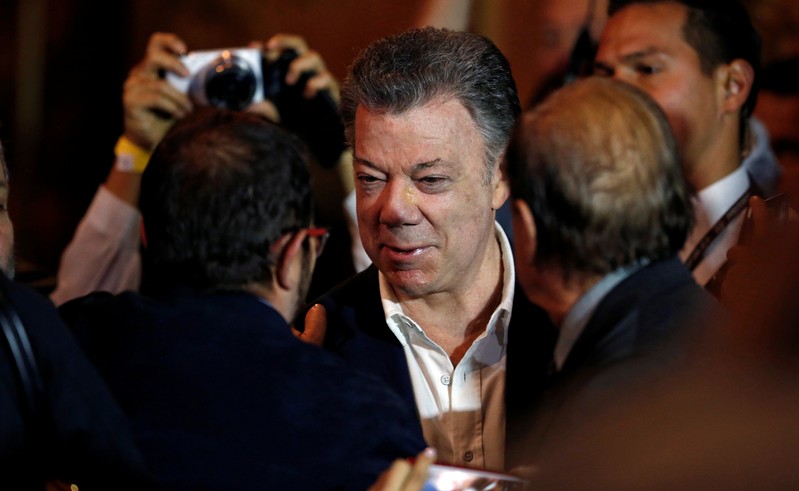 Colombia's President Juan Manuel Santos and Marxist FARC rebel leader Rodrigo Londono, known as Timochenko, shake hands after celebrating a year of peace signing in Bogota
