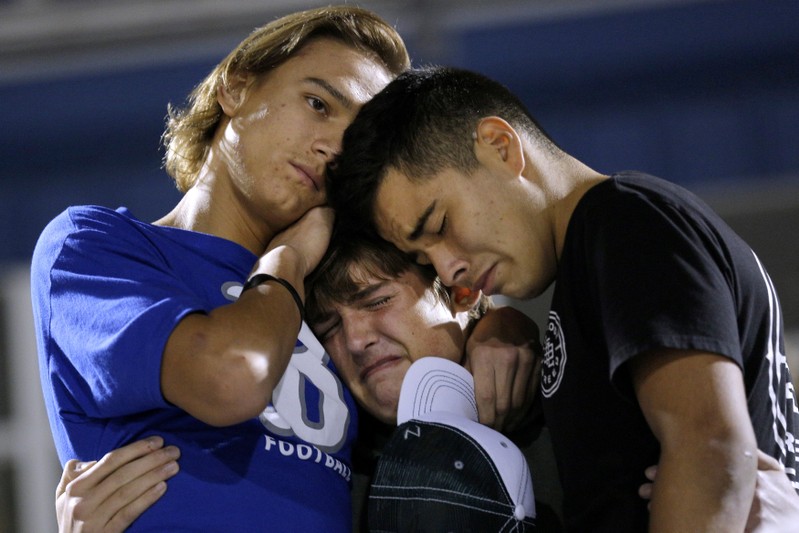 Daniel Friesenhahn is comforted by Derrick Barnhardt and Chris Johnson during a vigil in the memory of those killed in the shooting at the First Baptist Church of Sutherland Springs in La Vernia