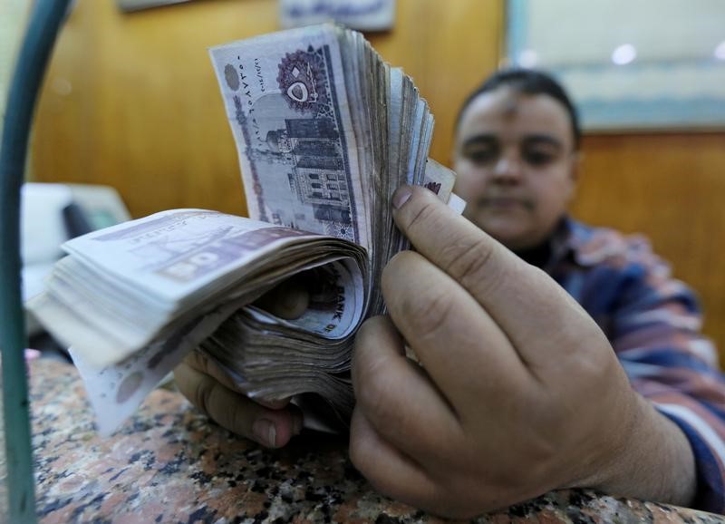 FILE PHOTO: An employee counts Egyptian pounds in a foreign exchange office in central Cairo