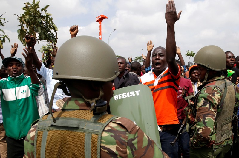 Riot police officers control supporters of Kenyan opposition leader Raila Odinga of the National Super Alliance coalition from accessing the Jomo Kenyatta airport upon his return in Nairobi