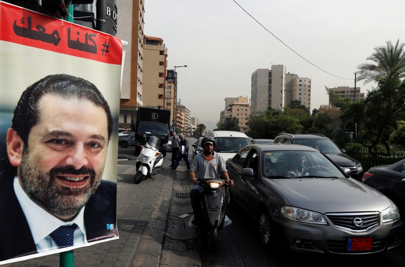Cars pass next to a poster depicting Saad al-Hariri, who has resigned as Lebanon's prime minister, in Beirut