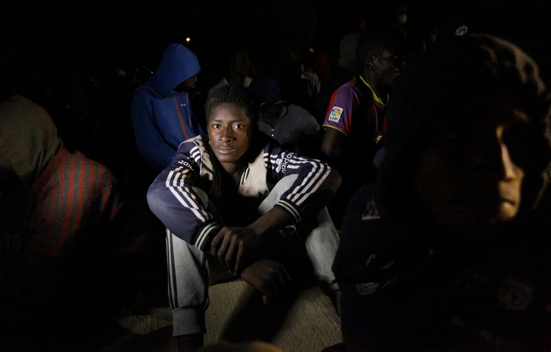 Migrants sit at a naval base after they were rescued by Libyan coastguard, in Tripoli